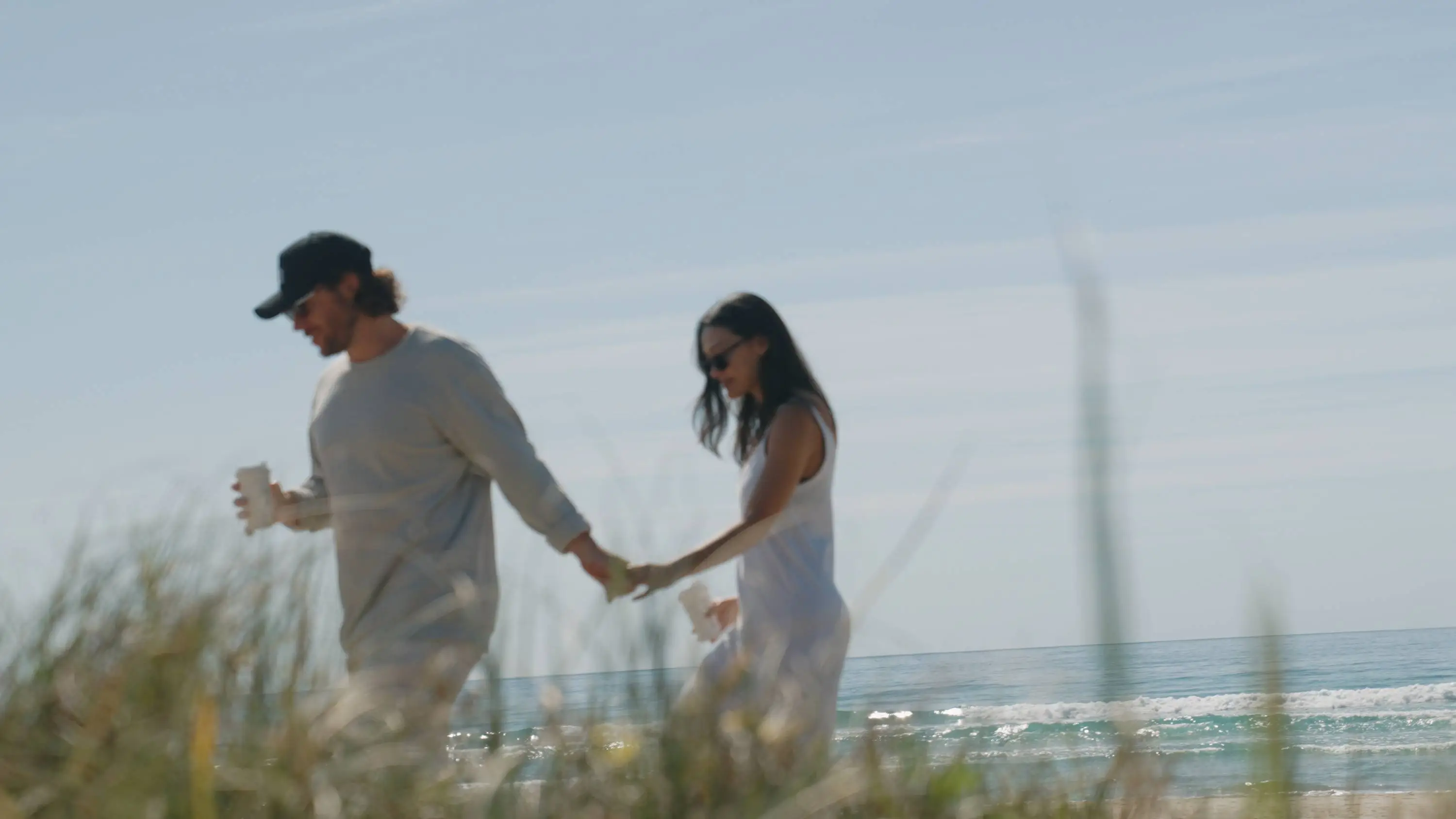 Beach walk couple sunset coffee date