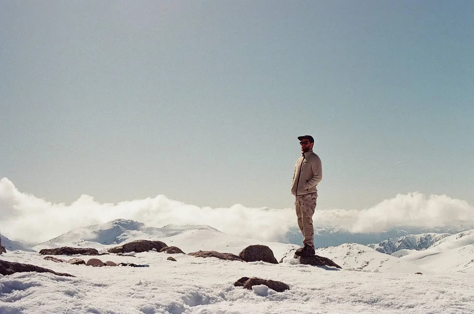 Snowy mountain adventure man standing on rocks