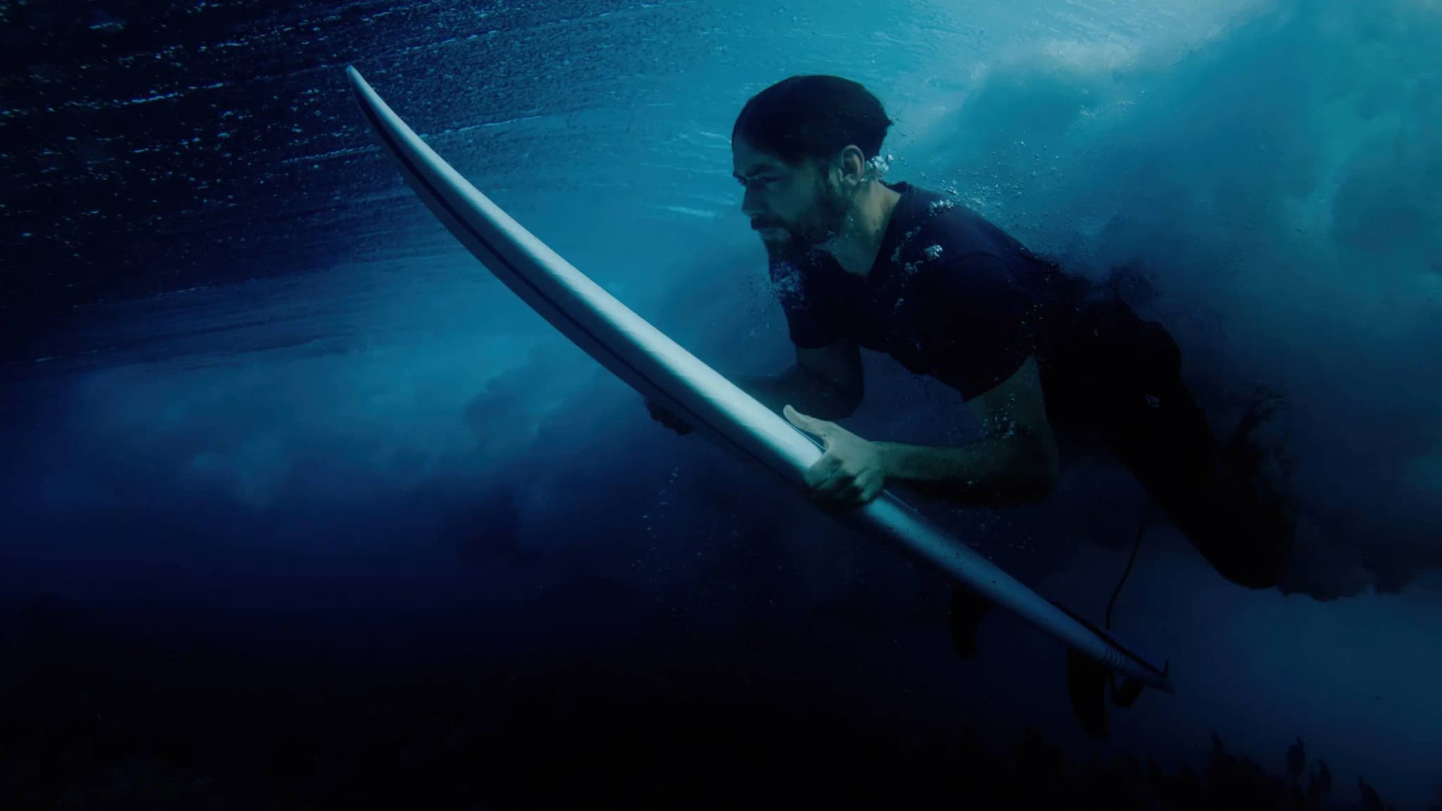 Underwater surfer diving into waves ocean adventure